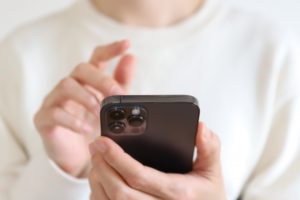 スマートフォンを操作する女性の手の画像